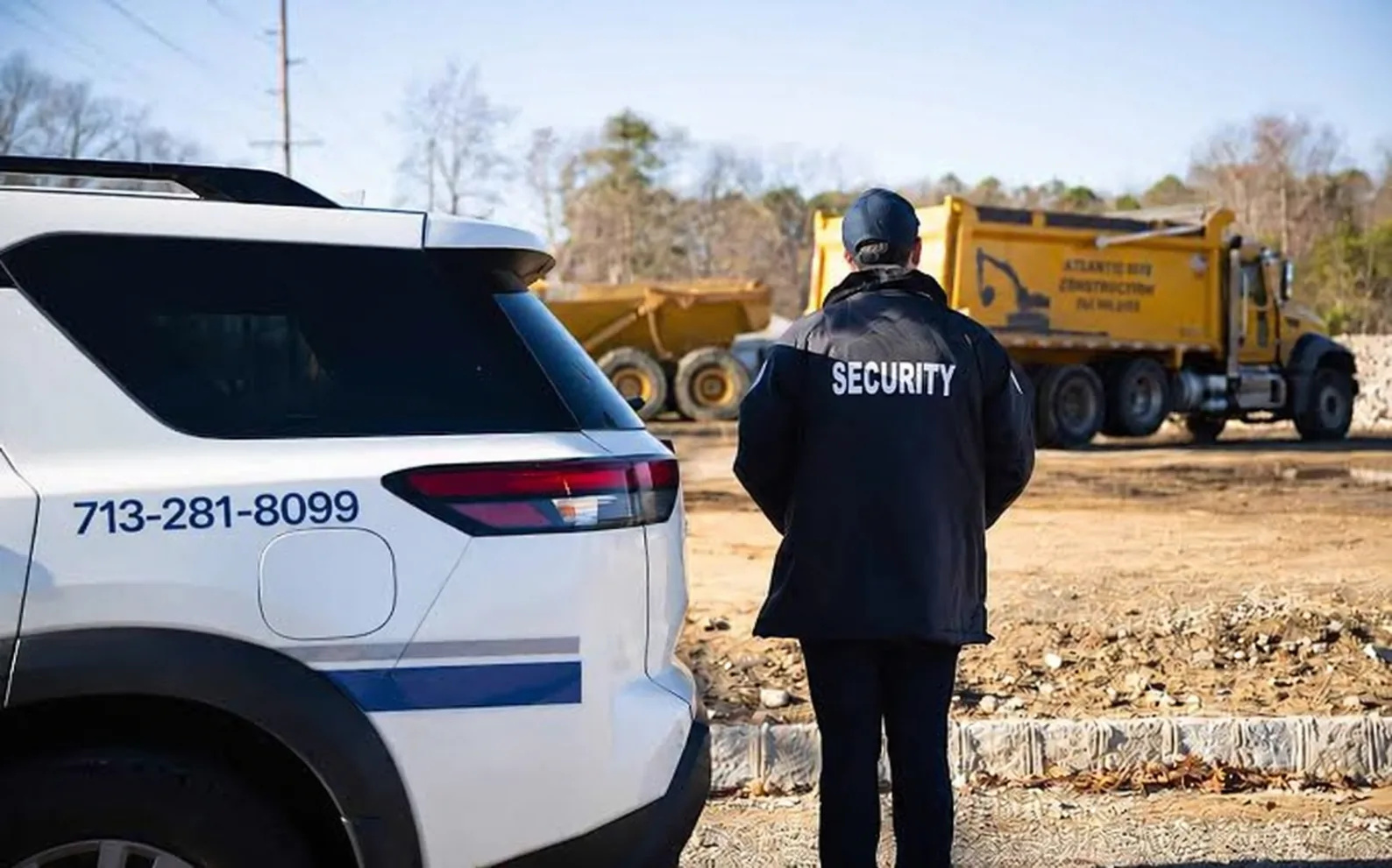 Security officer and marked patrol vehicle at a construction site