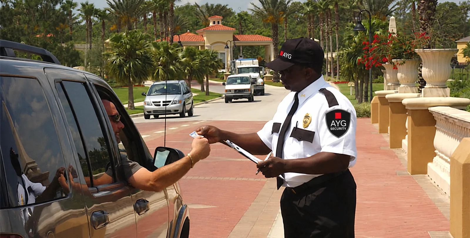 AYG Security officer checking a visitor ID at a gated community entrance